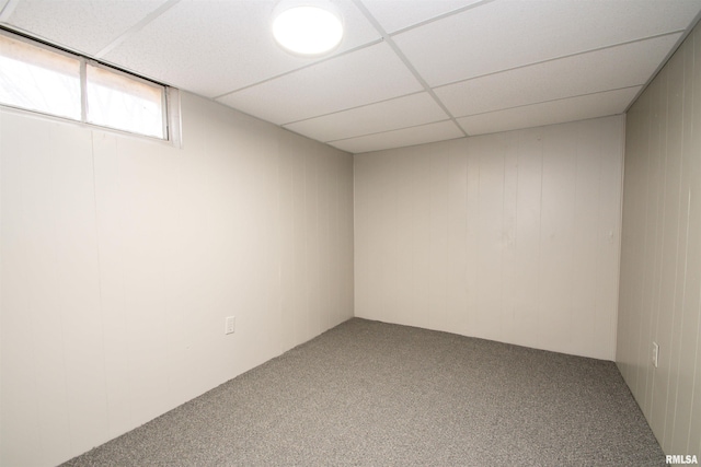 basement with a paneled ceiling and carpet floors