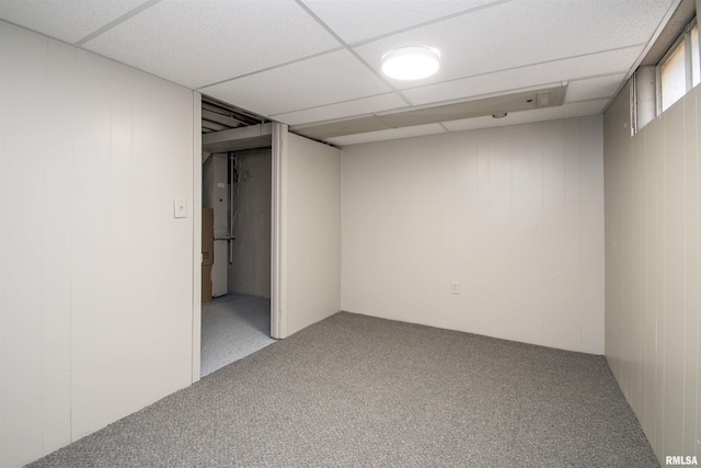 carpeted spare room featuring a paneled ceiling