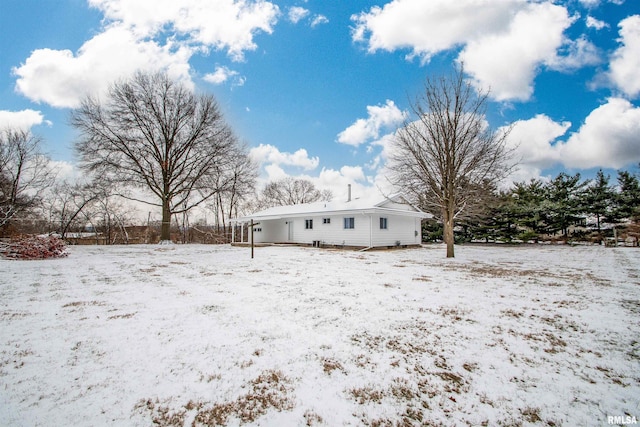 view of snow covered back of property