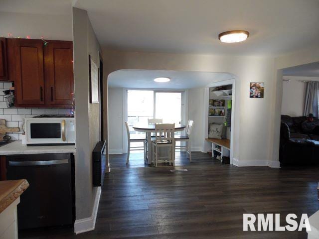 kitchen with tasteful backsplash, black dishwasher, and dark hardwood / wood-style floors