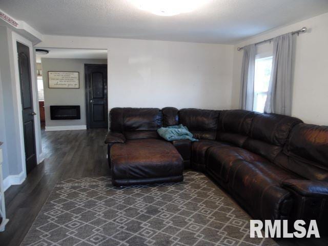 living room featuring a textured ceiling and dark hardwood / wood-style floors