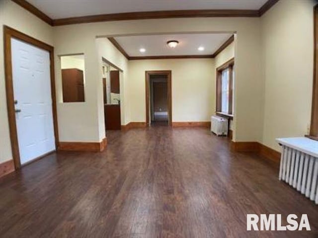 spare room with dark hardwood / wood-style flooring, crown molding, and radiator heating unit