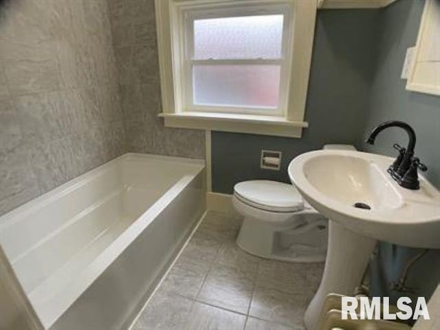 bathroom with a washtub and toilet