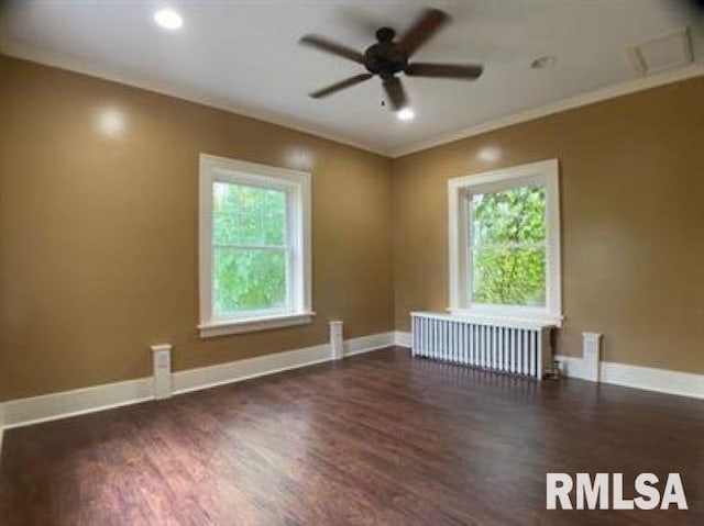 empty room with ceiling fan, crown molding, radiator, and dark hardwood / wood-style flooring