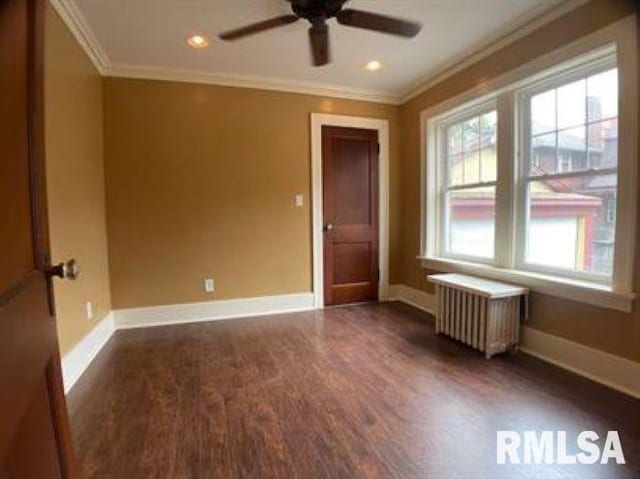 unfurnished room featuring ceiling fan, dark hardwood / wood-style flooring, crown molding, and radiator heating unit