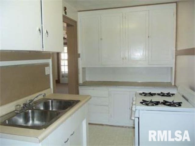 kitchen featuring sink, white range with gas cooktop, and white cabinets