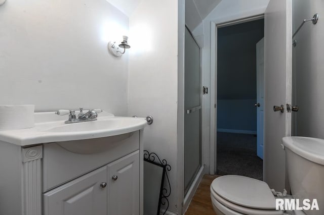 bathroom with hardwood / wood-style flooring, toilet, vanity, and vaulted ceiling