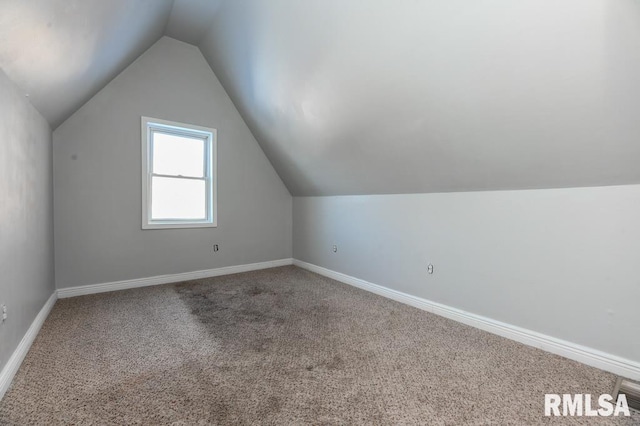 additional living space featuring carpet floors and vaulted ceiling