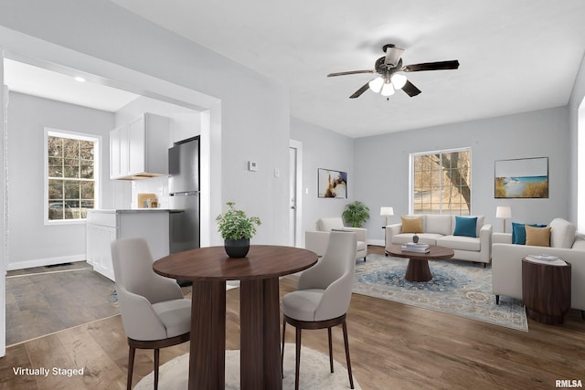 dining space with dark hardwood / wood-style flooring, a wealth of natural light, and ceiling fan