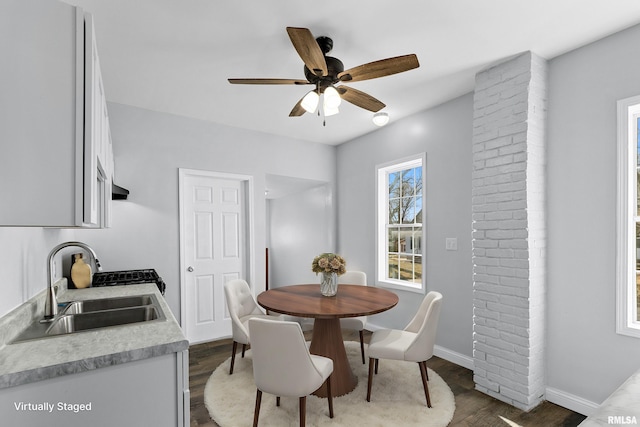 dining room with hardwood / wood-style flooring, ceiling fan, and sink