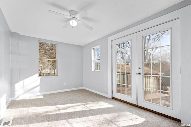 spare room featuring french doors, ceiling fan, and light carpet