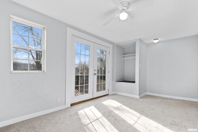 spare room with french doors, ceiling fan, and light carpet