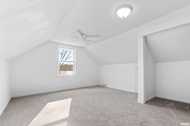 bonus room featuring ceiling fan, lofted ceiling, light carpet, and a textured ceiling