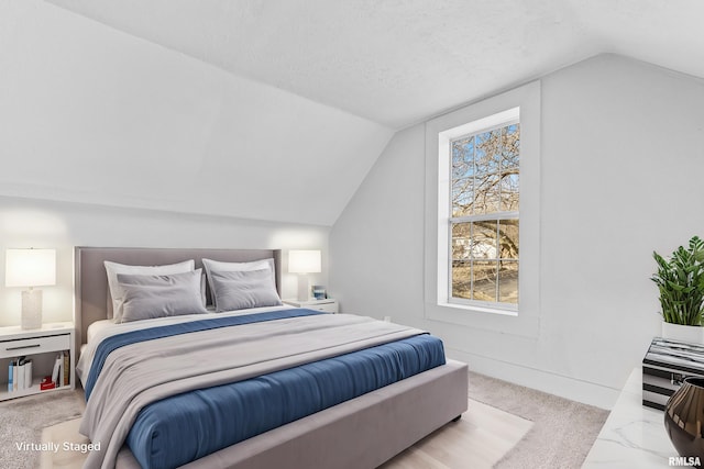 bedroom featuring lofted ceiling and a textured ceiling