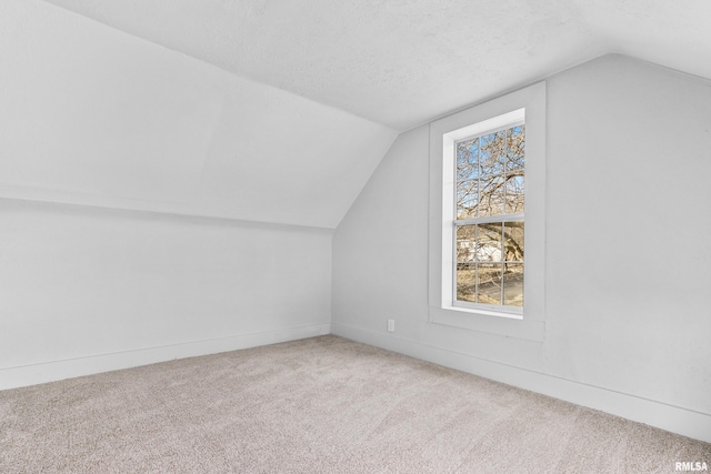 bonus room with lofted ceiling, carpet, and a textured ceiling