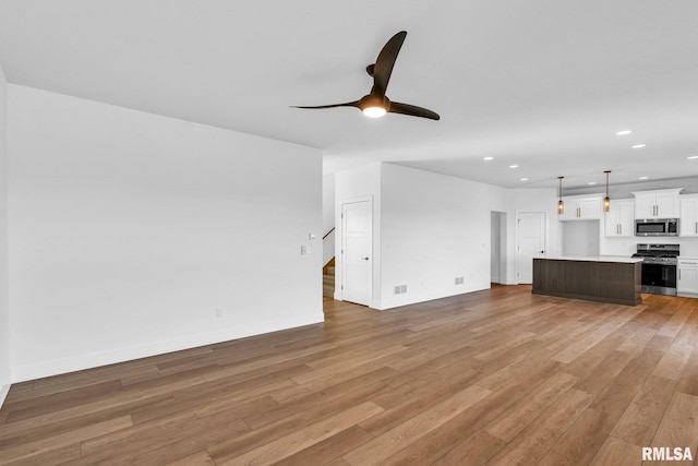 unfurnished living room with ceiling fan and light hardwood / wood-style floors