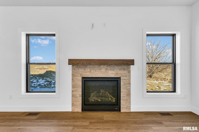 interior details with a tiled fireplace and hardwood / wood-style floors