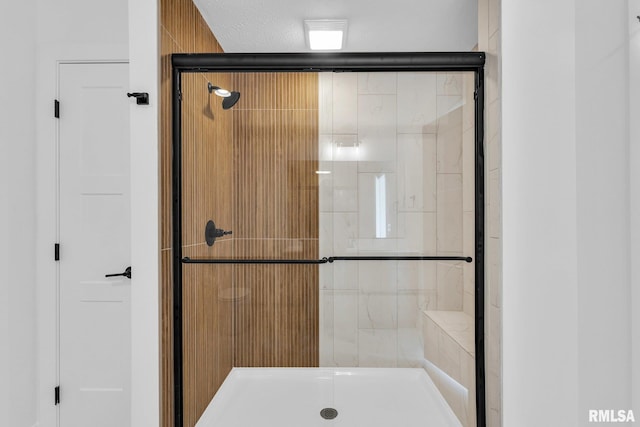 bathroom featuring an enclosed shower and a textured ceiling