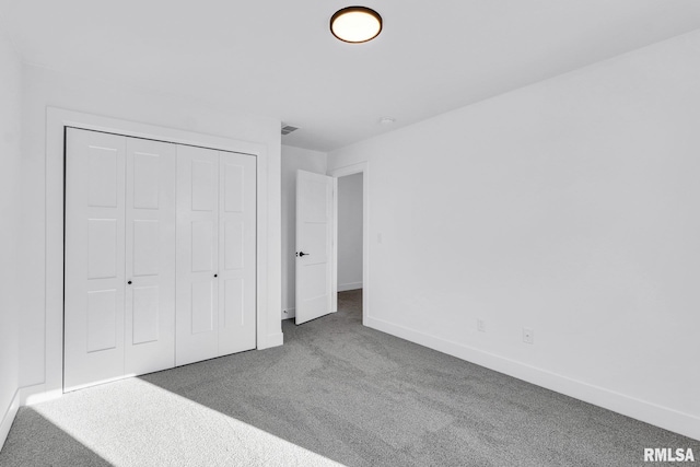 unfurnished bedroom featuring carpet flooring and a closet