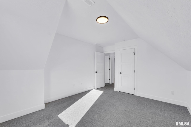 bonus room featuring lofted ceiling and dark carpet