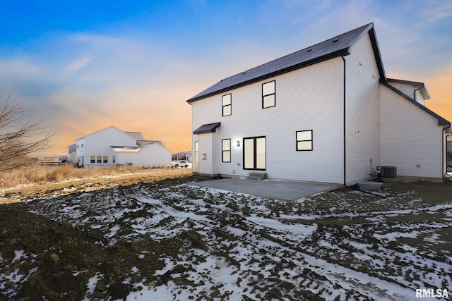 snow covered rear of property featuring a patio area and central air condition unit