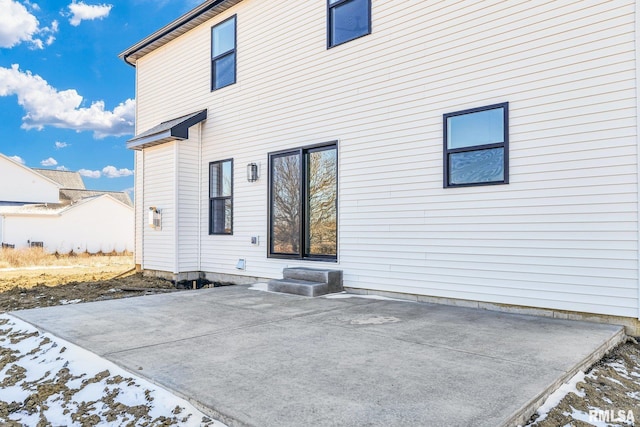 snow covered property with a patio