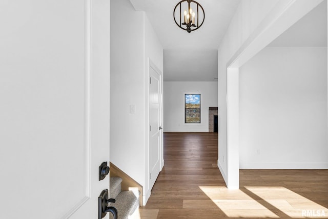 hallway featuring hardwood / wood-style floors and a notable chandelier