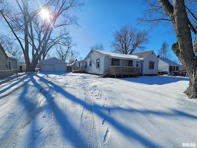 snow covered property with a garage, an outdoor structure, and a porch