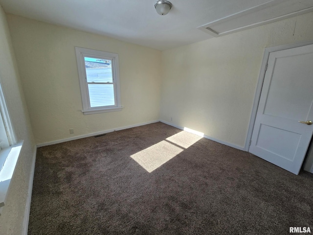 unfurnished room with dark colored carpet