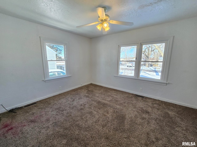 carpeted empty room featuring ceiling fan and a textured ceiling