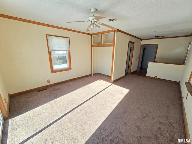 empty room featuring ceiling fan, a textured ceiling, crown molding, and carpet flooring