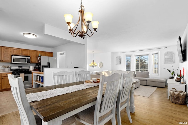 dining room featuring light hardwood / wood-style flooring and an inviting chandelier