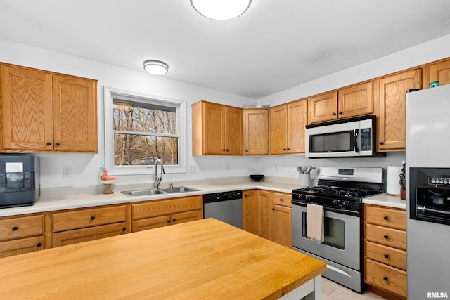 kitchen with butcher block counters, sink, and stainless steel appliances