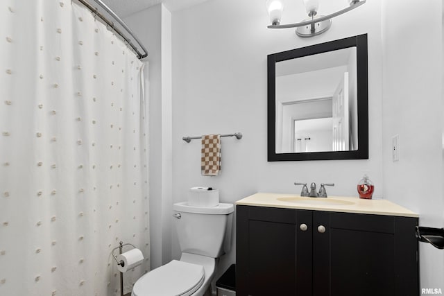 bathroom featuring toilet, an inviting chandelier, and vanity