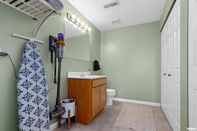 bathroom featuring tile patterned floors, a textured ceiling, toilet, and vanity