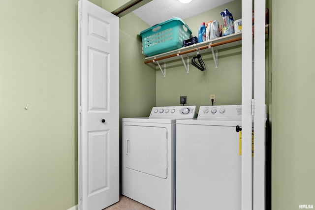 laundry area featuring a textured ceiling, light tile patterned floors, and independent washer and dryer