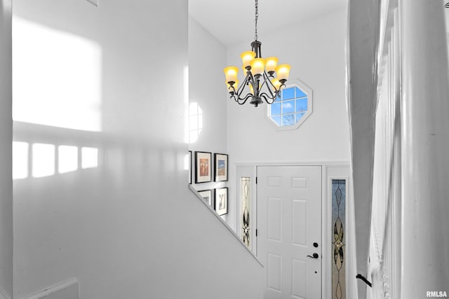 foyer entrance featuring a towering ceiling and a notable chandelier