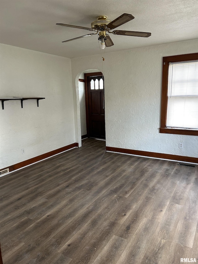 interior space with dark wood-type flooring, ceiling fan, and a textured ceiling