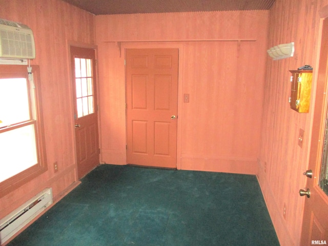 interior space with a wall unit AC, wood walls, and a baseboard radiator