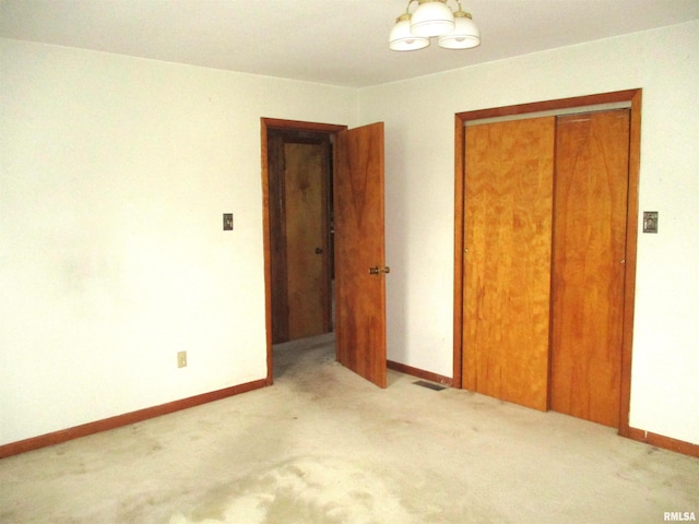 unfurnished bedroom featuring light colored carpet and a closet