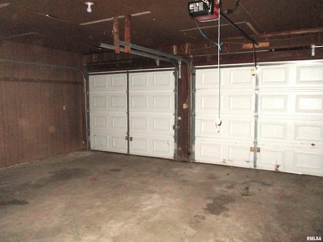 garage with wood walls and a garage door opener