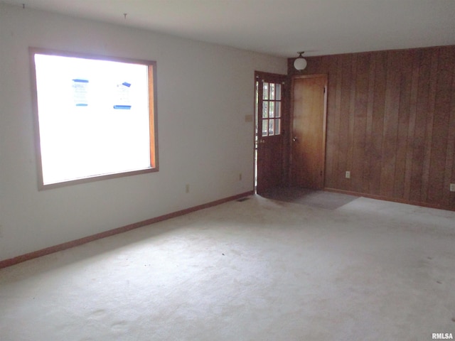 unfurnished room featuring wooden walls