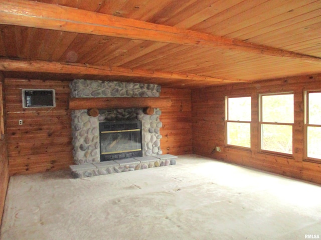 unfurnished living room with a stone fireplace and beamed ceiling