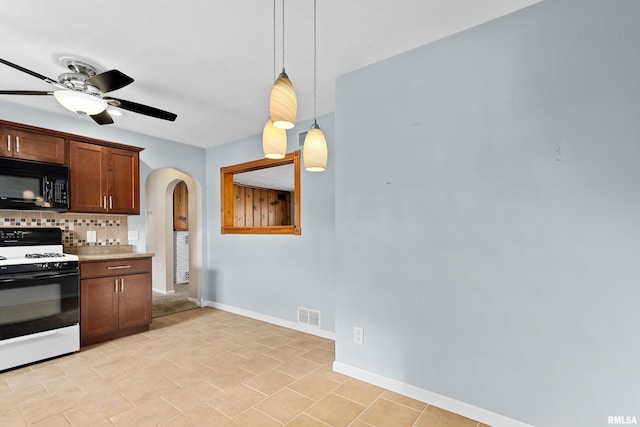 kitchen featuring tasteful backsplash, decorative light fixtures, gas stove, and ceiling fan