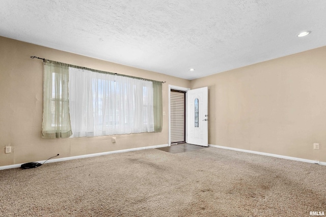 carpeted spare room featuring a textured ceiling