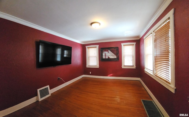 spare room featuring ornamental molding and hardwood / wood-style flooring