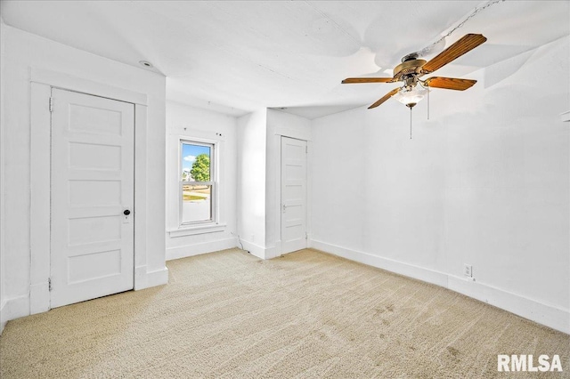 empty room featuring ceiling fan and light colored carpet