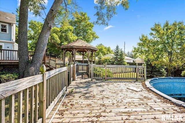 wooden terrace with a covered pool and a gazebo