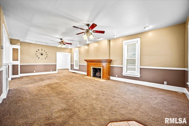 unfurnished living room with ceiling fan and carpet flooring