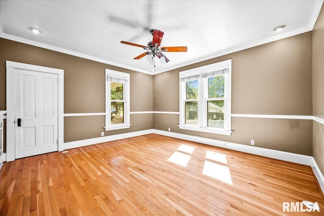 unfurnished room with ceiling fan, light wood-type flooring, and ornamental molding